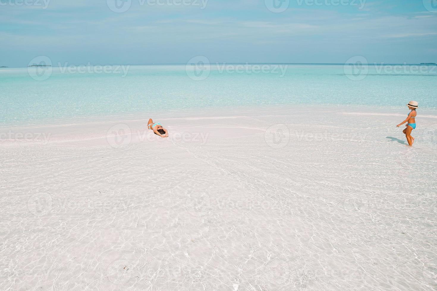 Little girl and young mother during beach vacation photo