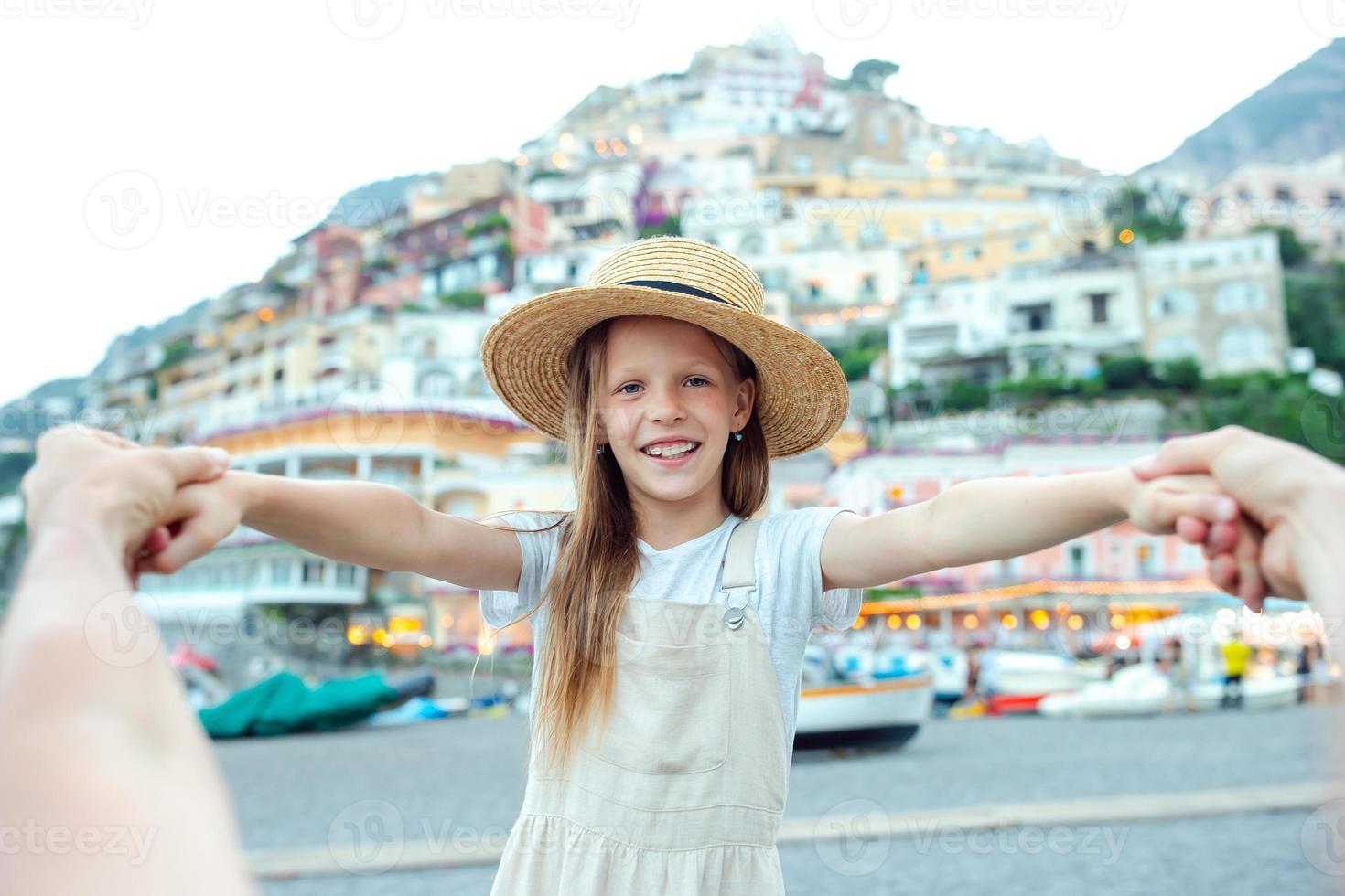 Adorable little girl on warm and sunny summer day in Positano town in Italy photo