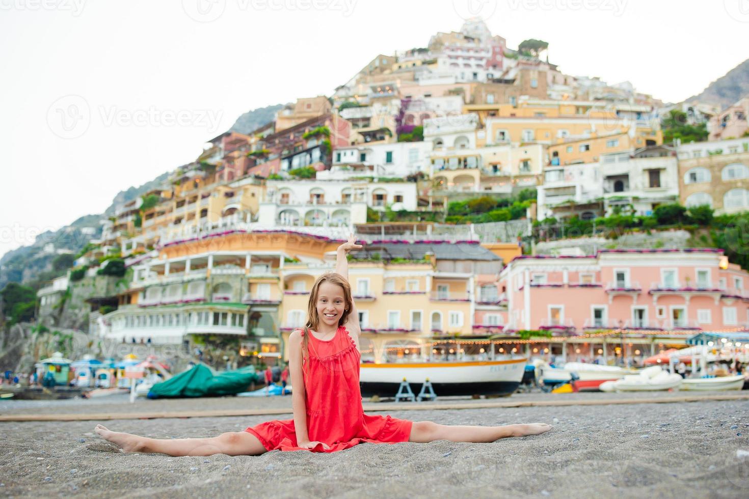 Adorable little girl on warm and sunny summer day in Positano town in Italy photo