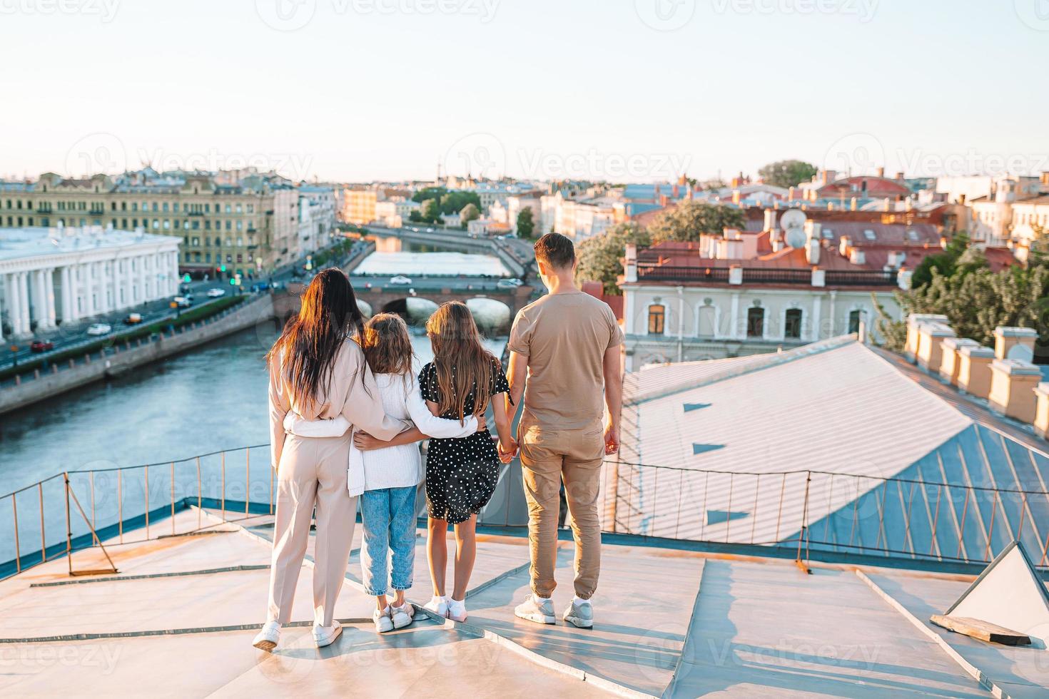 Family on rooftop enjoying with view of beautiful sunset in Sankt Petersburg in Russia photo