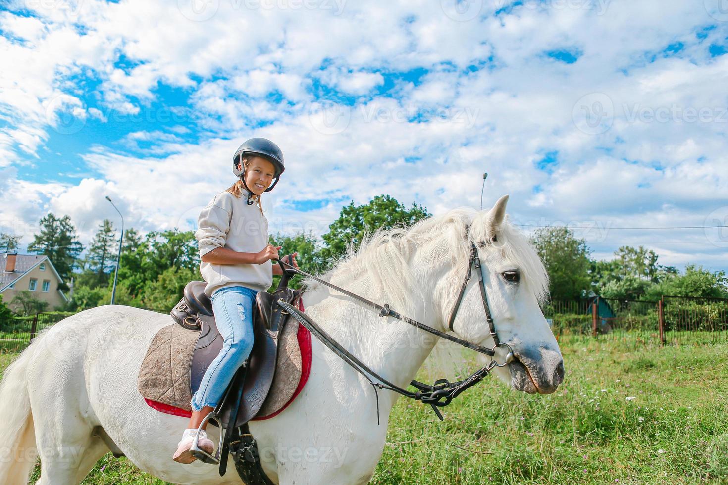 niña montando un caballo blanco en la naturaleza foto