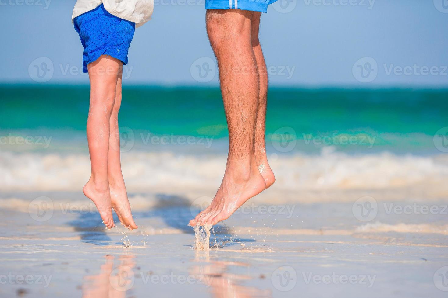 Little girl and happy dad having fun during beach vacation photo