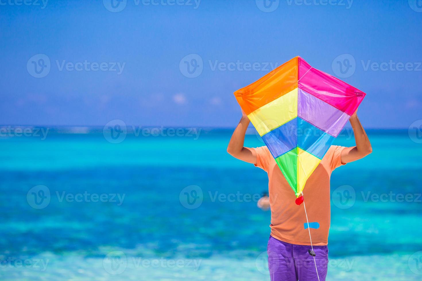 Young man with a kite on a background of turquoise sea photo