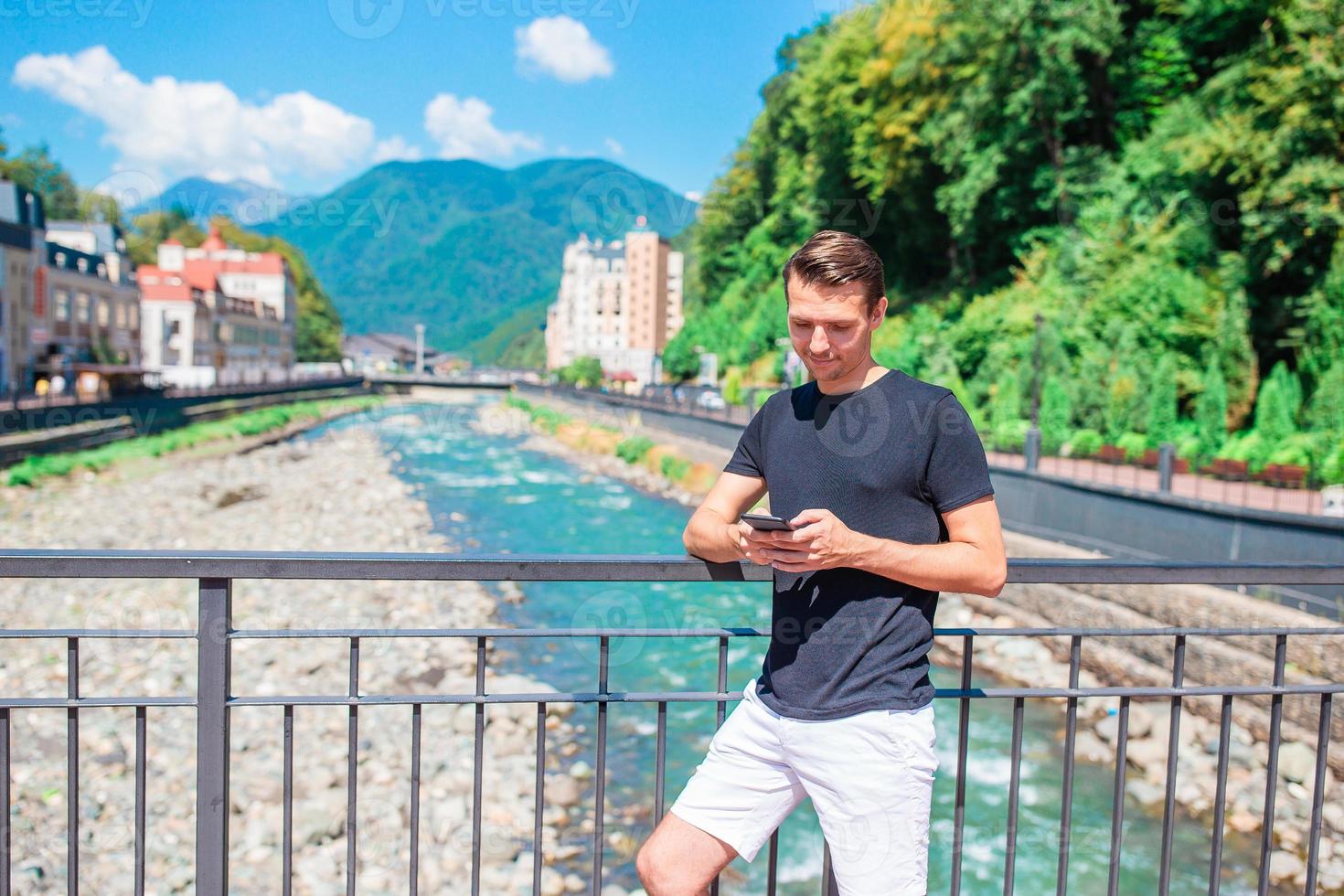 hombre en la orilla de un río de montaña en una ciudad europea. foto