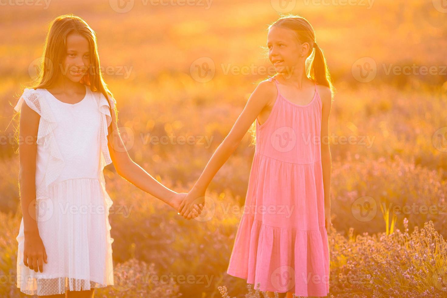 Girls in lavender flowers field at sunset in white dress photo
