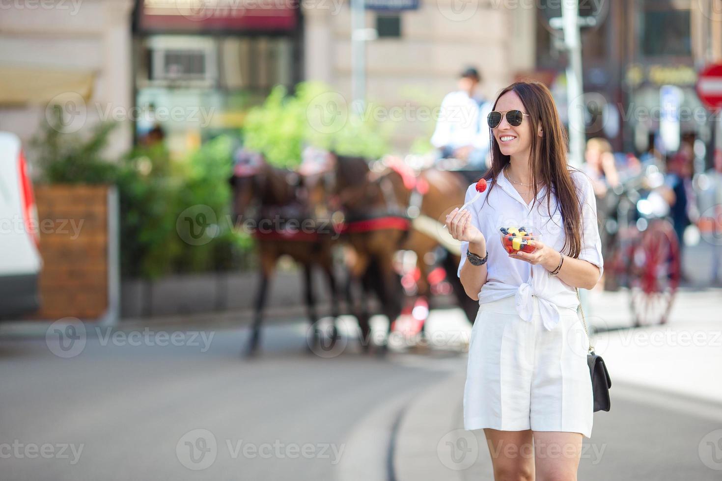 chica turista disfrutando de un paseo por viena y mirando los hermosos caballos en el carruaje foto
