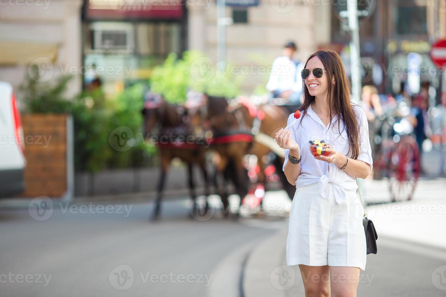 Tourist girl enjoying a stroll through Vienna and looking at the beautiful horses in the carriage photo