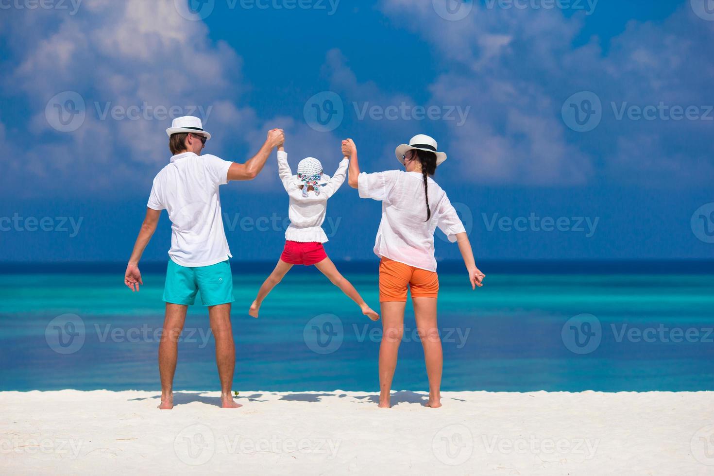 Young family on white beach during summer vacation photo