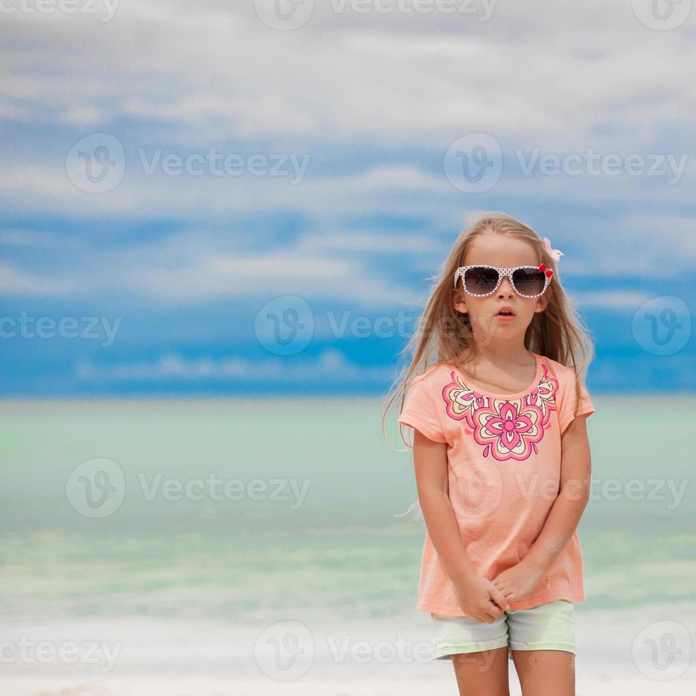 Adorable little girl on tropical beach vacation photo