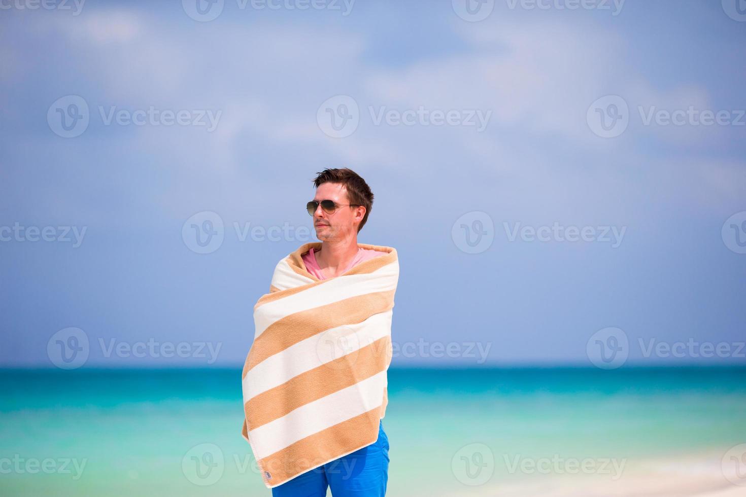 Boy boy wrapped in towel at tropical beach photo