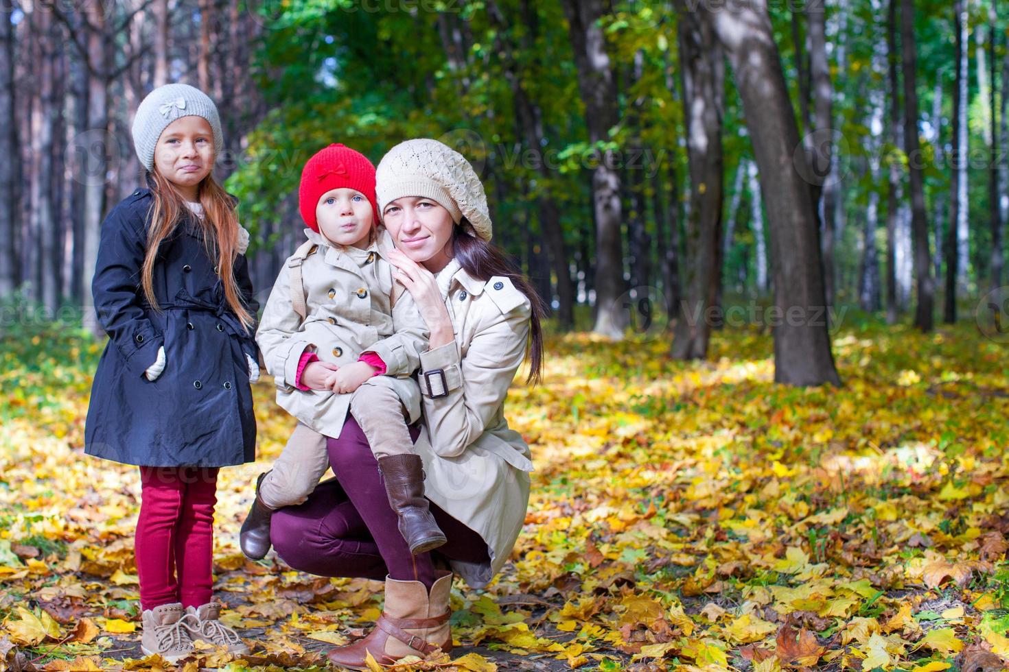 joven madre con su maravillosa y hermosa hija camina en el parque de otoño en un día cálido y soleado foto