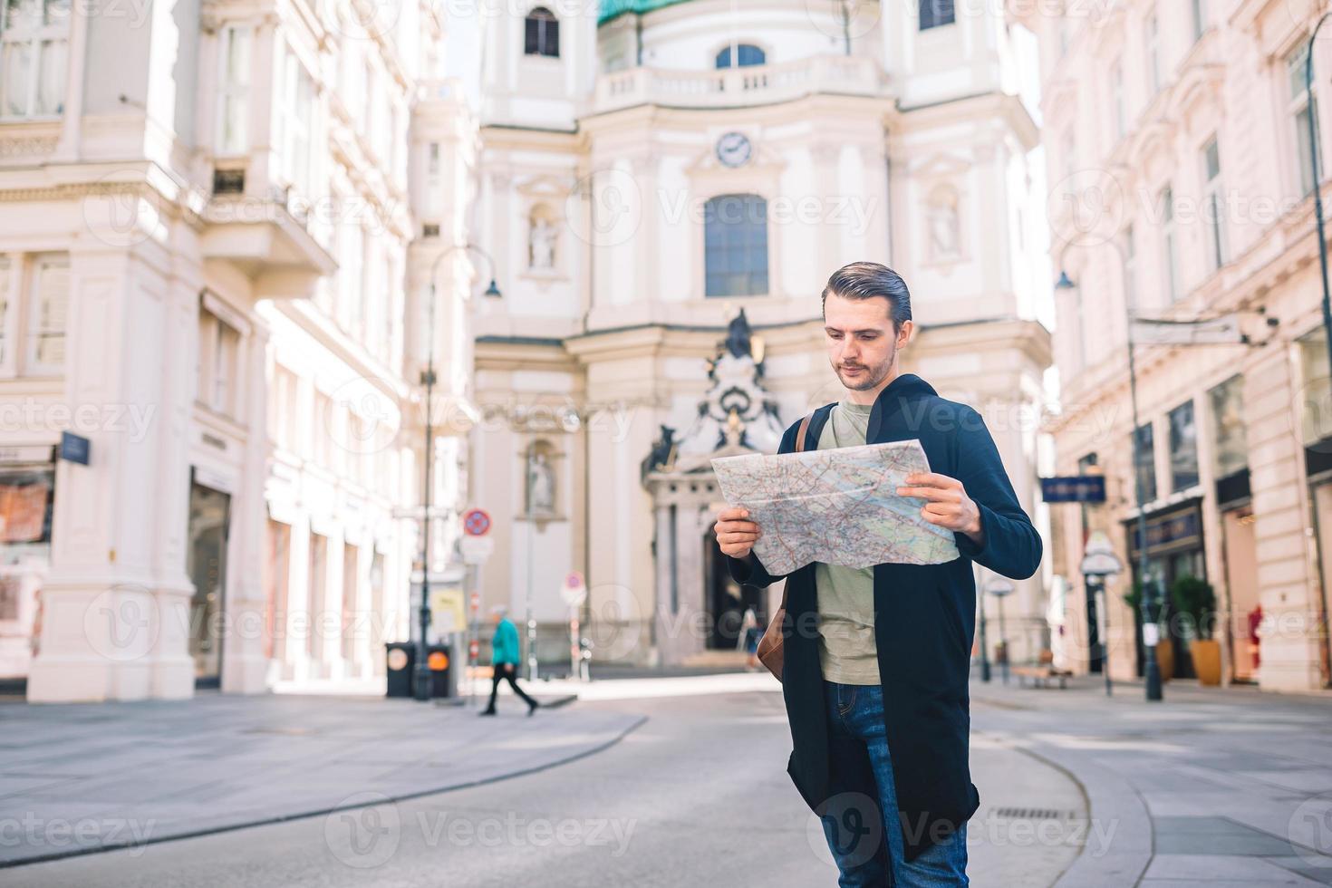 Man tourist with a city map and backpack in Europe street. photo