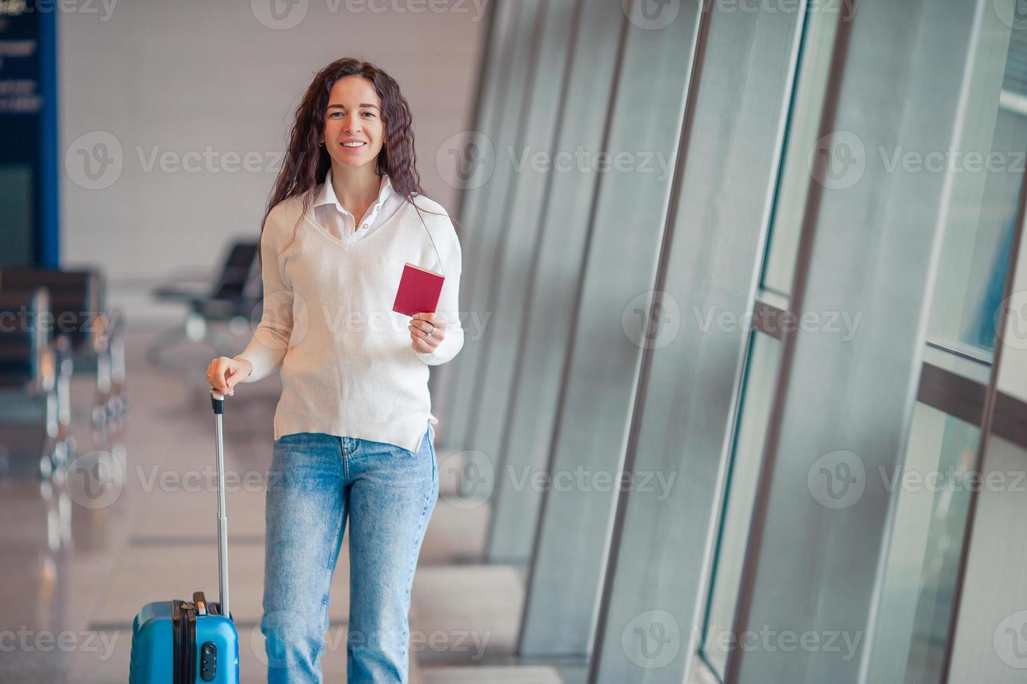 Young woman with luggage in international airport. Airline passenger in an airport lounge waiting for flight aircraft photo