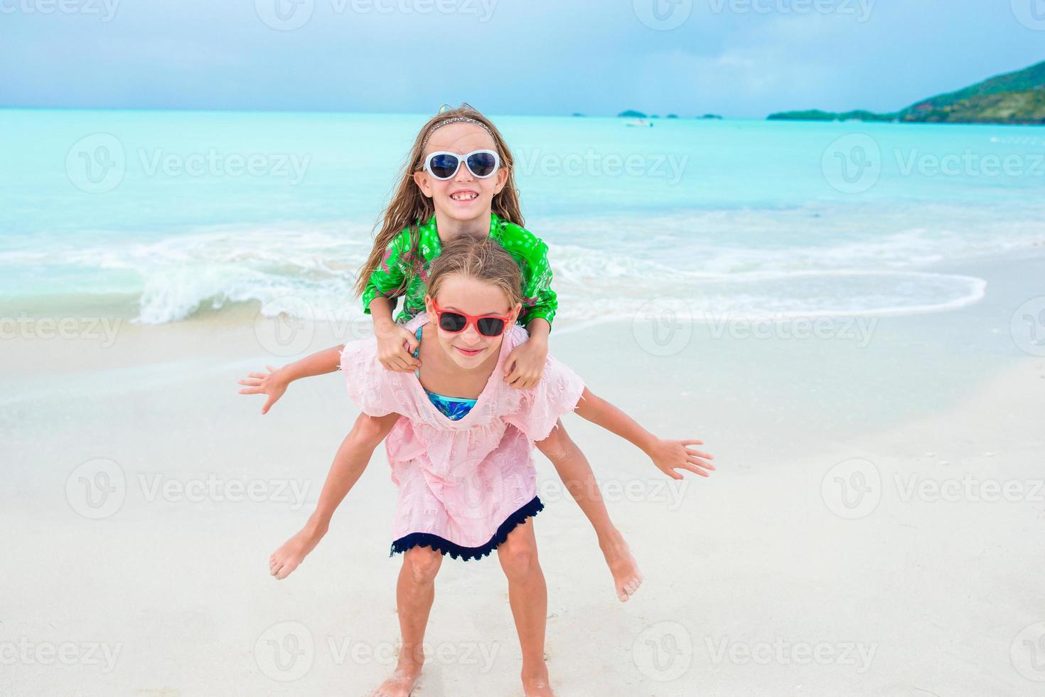 Adorable little girls walking on the beach photo