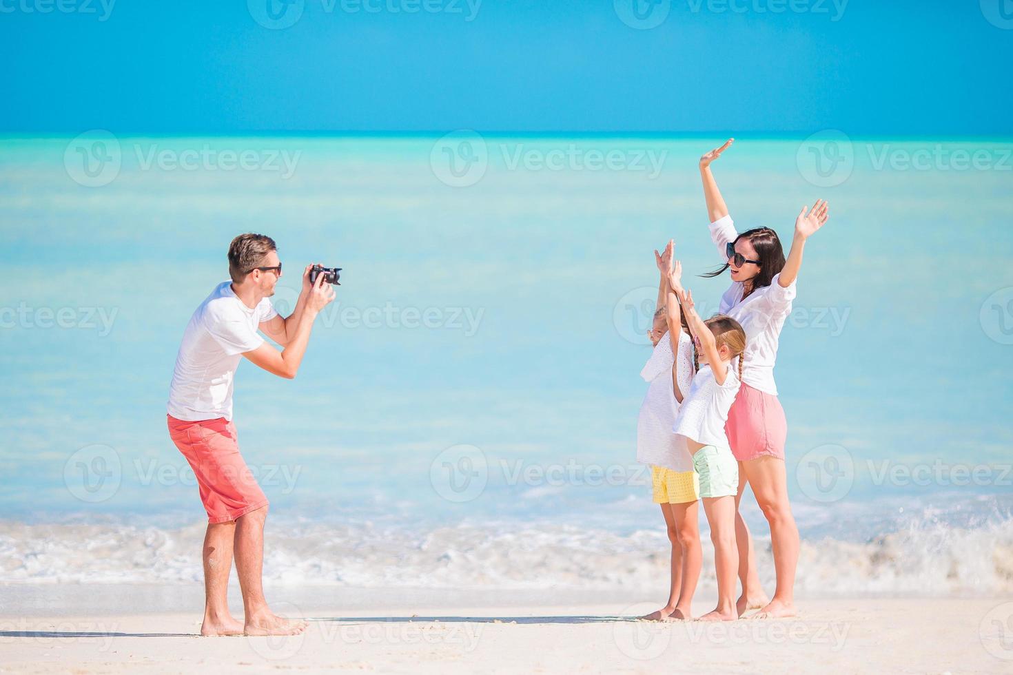 Family of four taking a selfie photo on their beach holidays. Family beach vacation