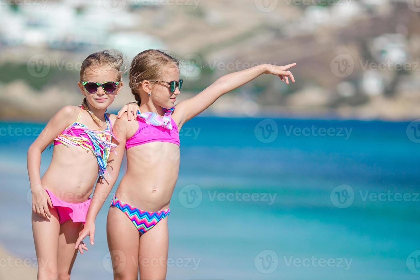 Two little girls together on the beach on vacation photo