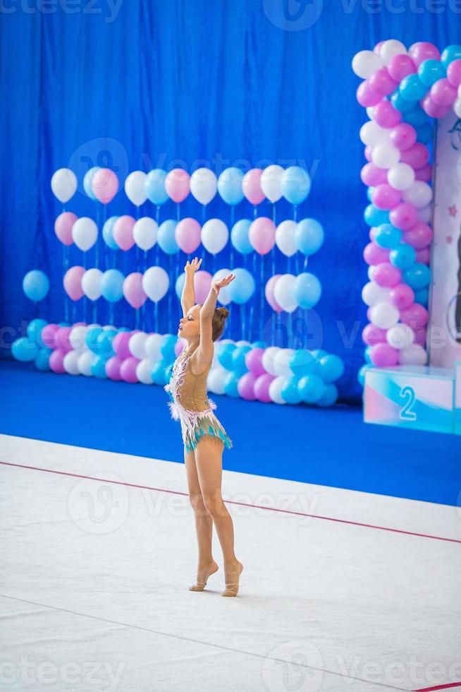 hermosa niña gimnasta activa con su actuación en la alfombra foto