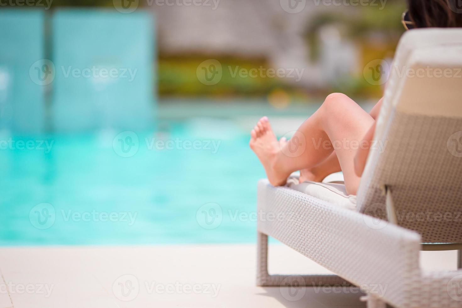 mujer tomando el sol en una tumbona en un resort tropical foto