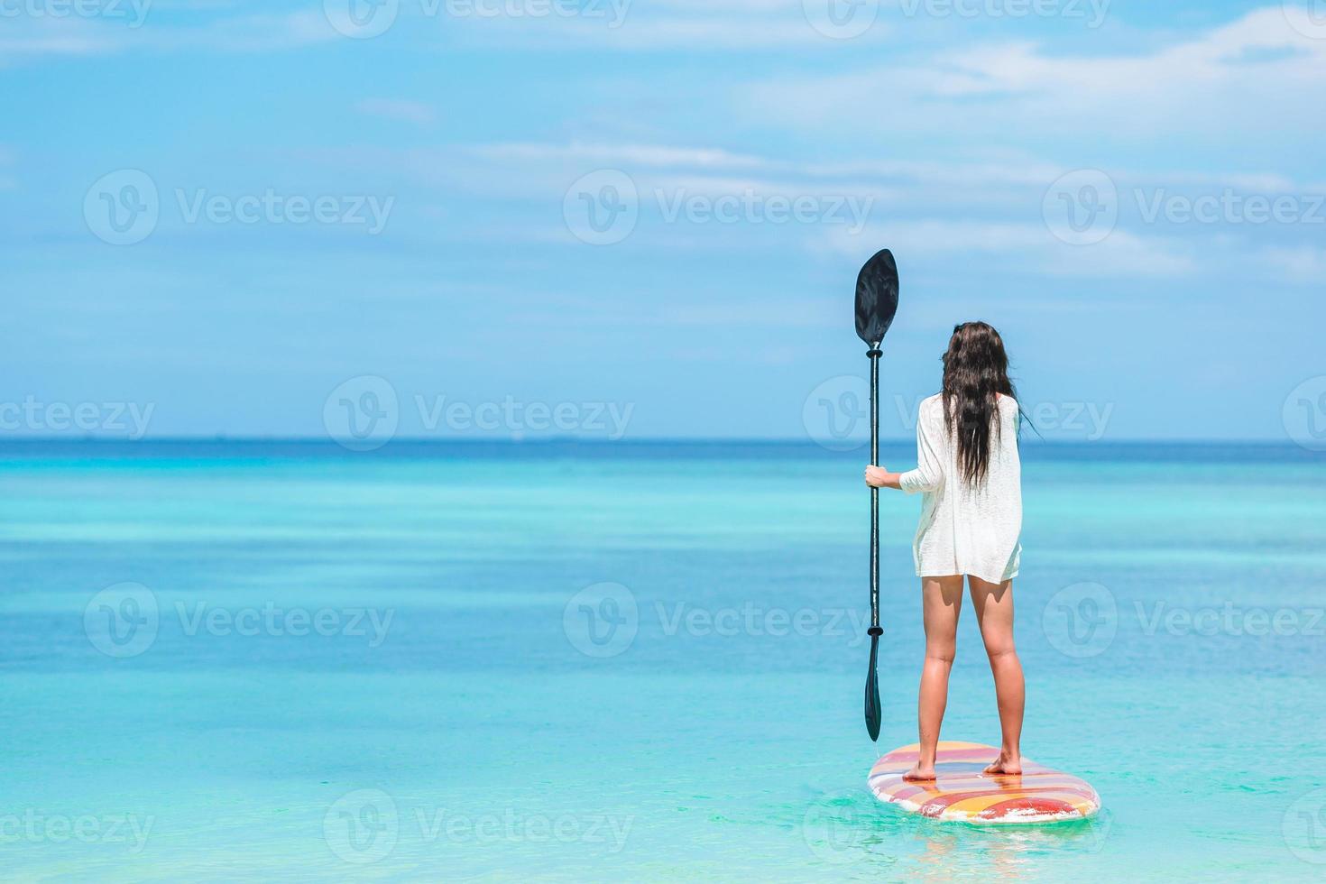 mujer joven activa en stand up paddle board foto