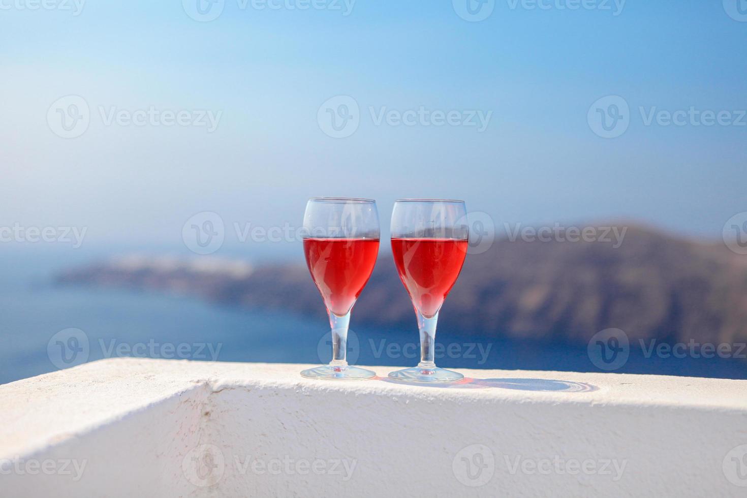 Two glasses of tasty red wine at sunset in Greece photo