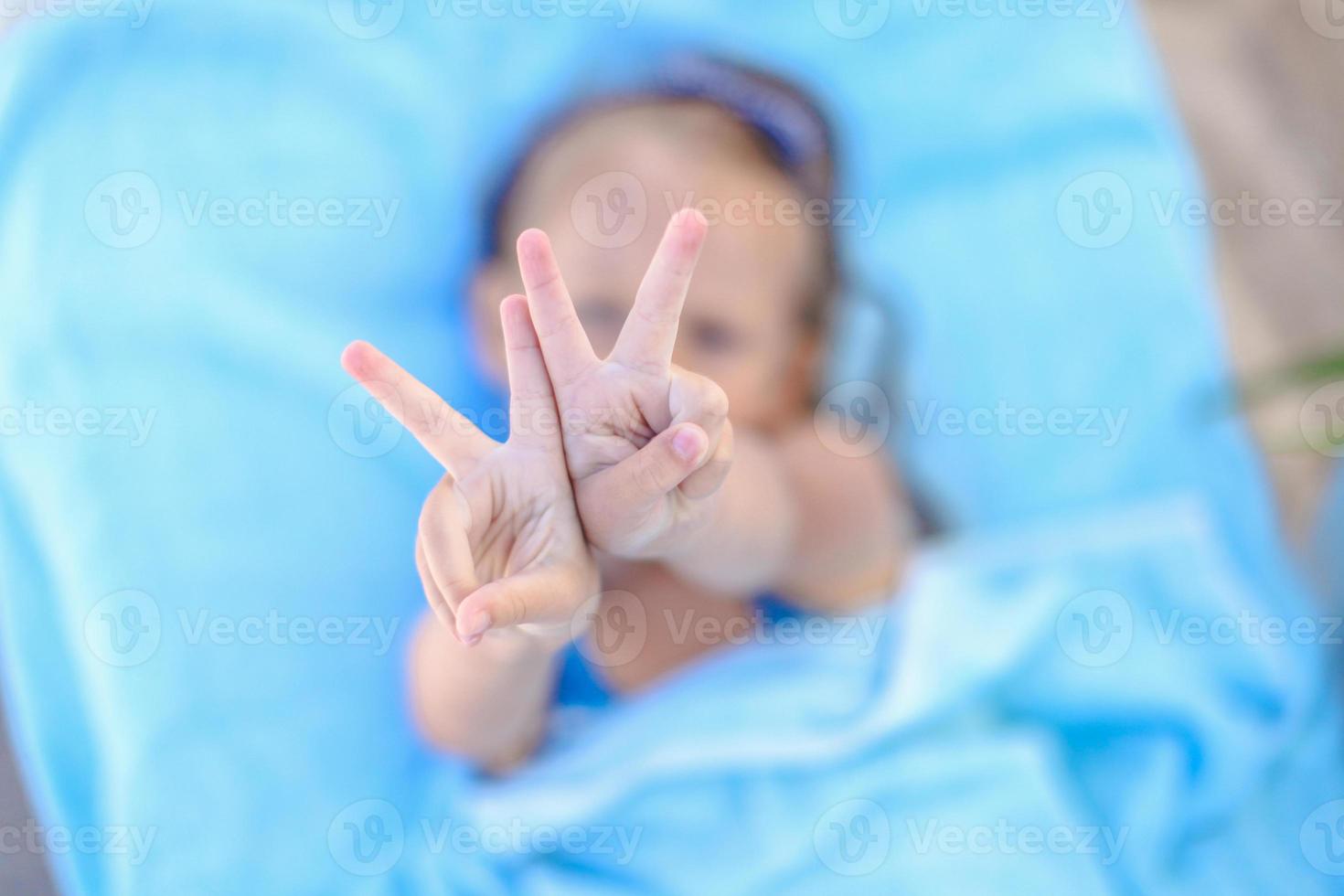 niña mostrando los pulgares hacia arriba al aire libre foto