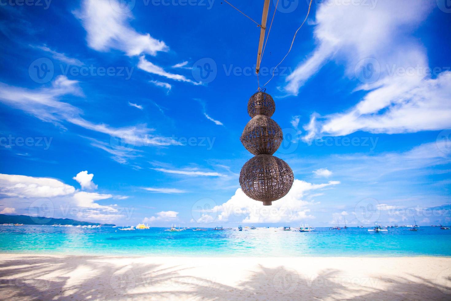 Unusual lantern on the white beach background blue sky photo