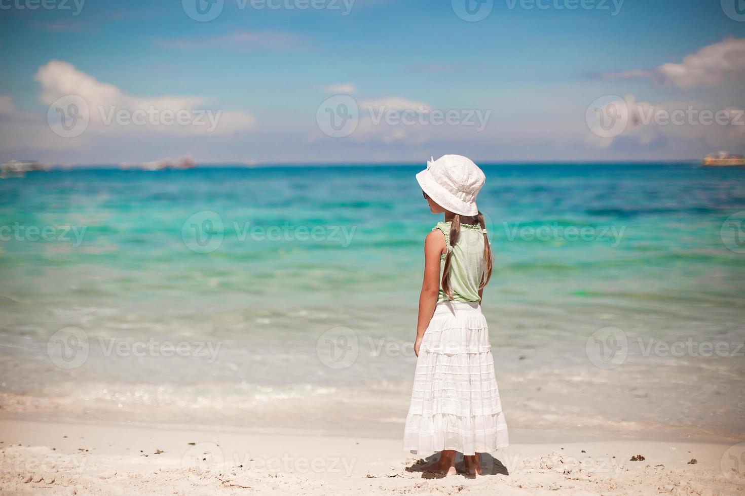Adorable niña caminando en la playa blanca tropical foto