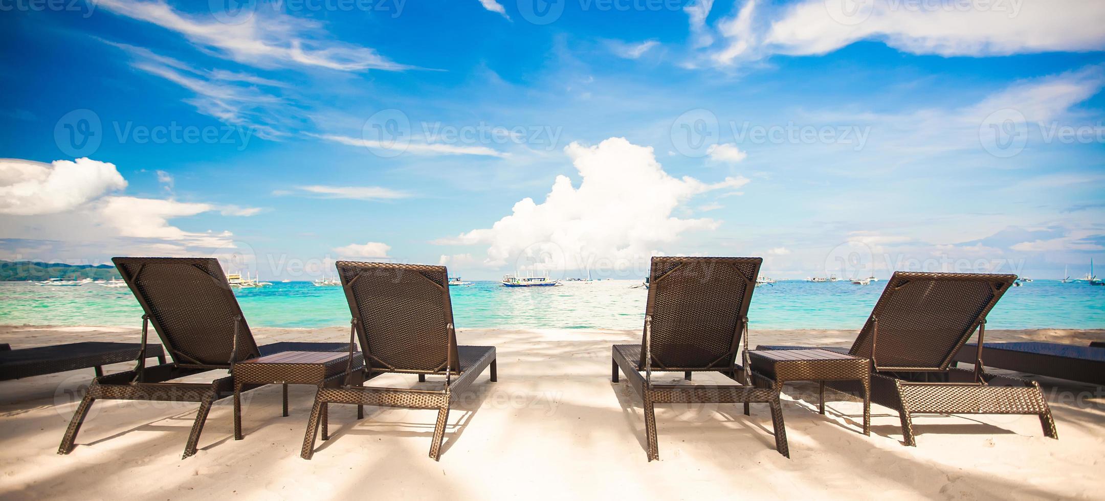 Beach chairs in exotic resort on perfect white sandy beach photo