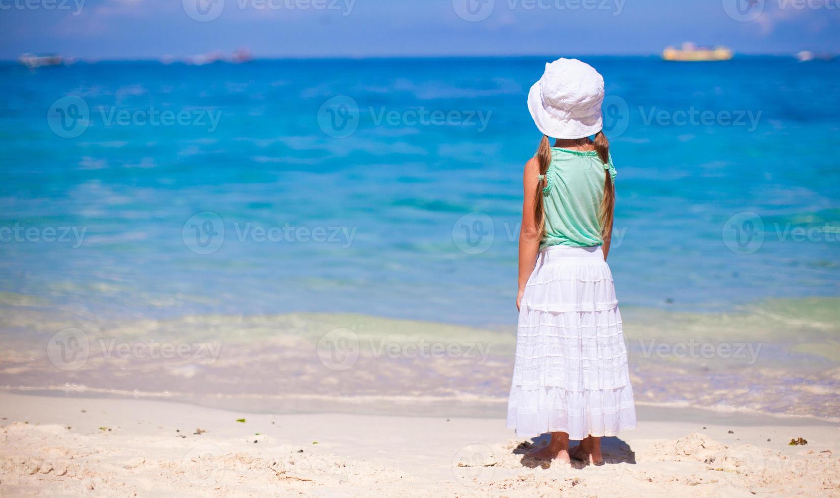 niña dulce en una playa tropical con agua turquesa foto