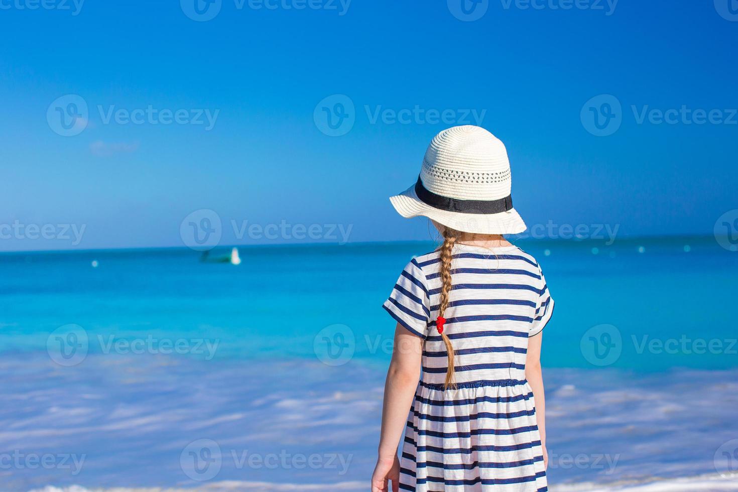 Adorable little girl at white beach during summer vacation photo