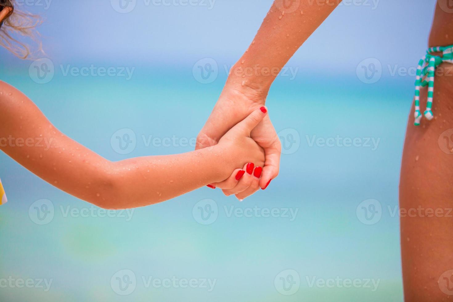 Trust family hands of child girl and mother on white beach photo