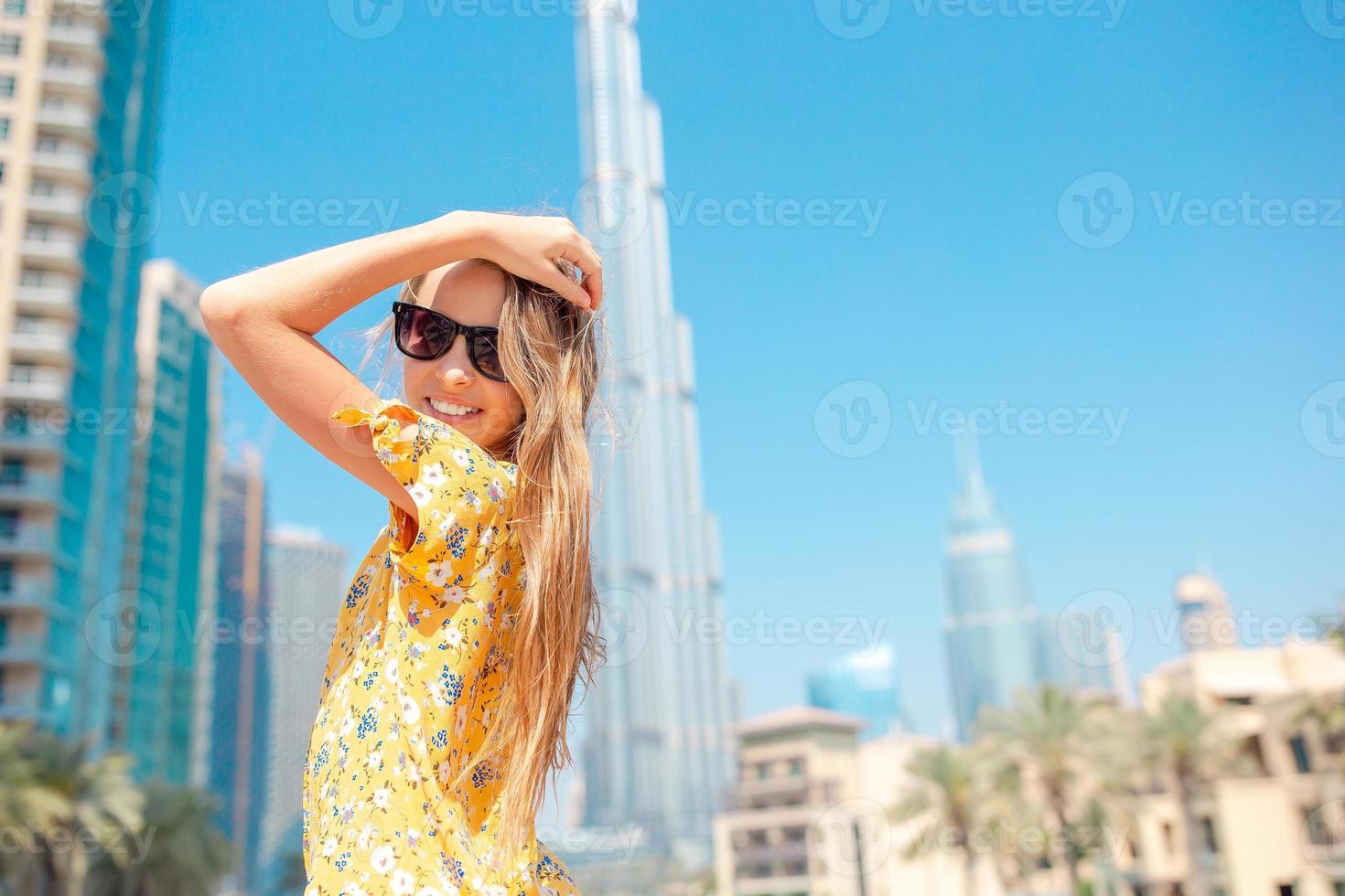 Happy girl walking in Dubai with skyscrapers in the background. photo