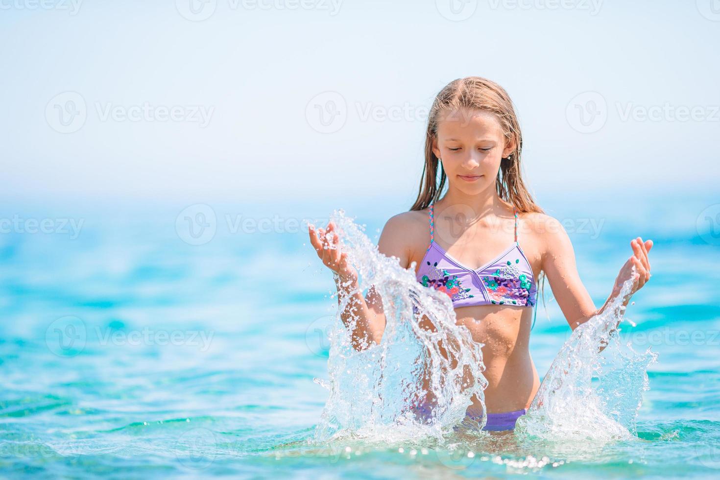 Cute little girl at beach during summer vacation photo