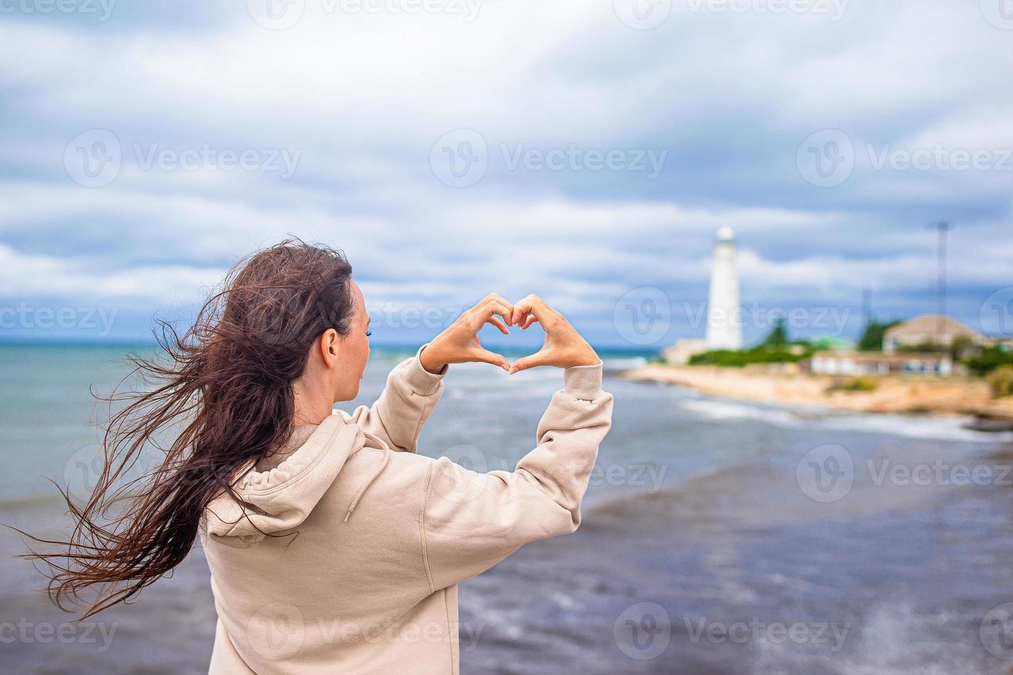 Woman walk to the lighthouse and make heart photo