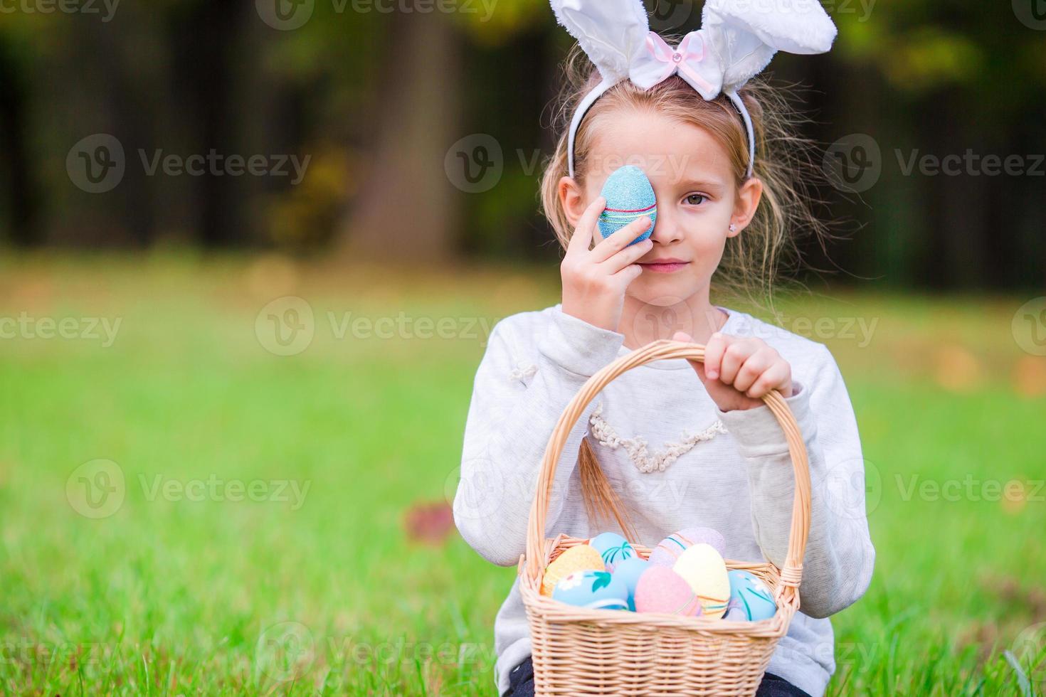 Portrait of little happy kid on Easter playing with easter eggs outdoor photo