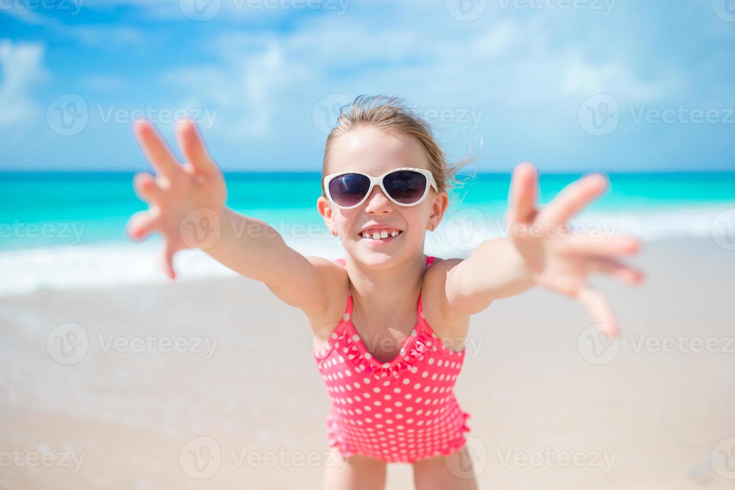 adorable niña en la playa divirtiéndose mucho foto