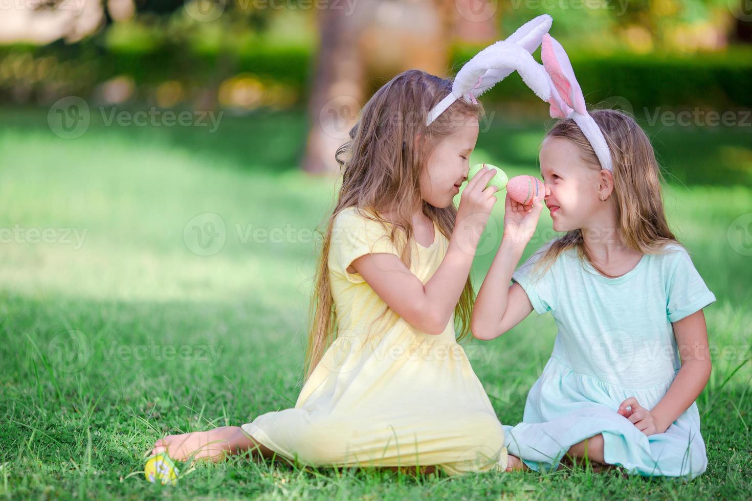 Kids in bunny ears have fun on Easter day outdoors photo