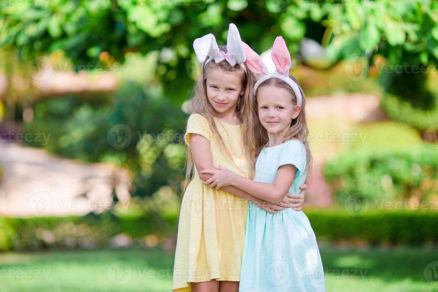 Girls wearing bunny ears on Easter day outdoors. Kids enjoy easter holiday photo