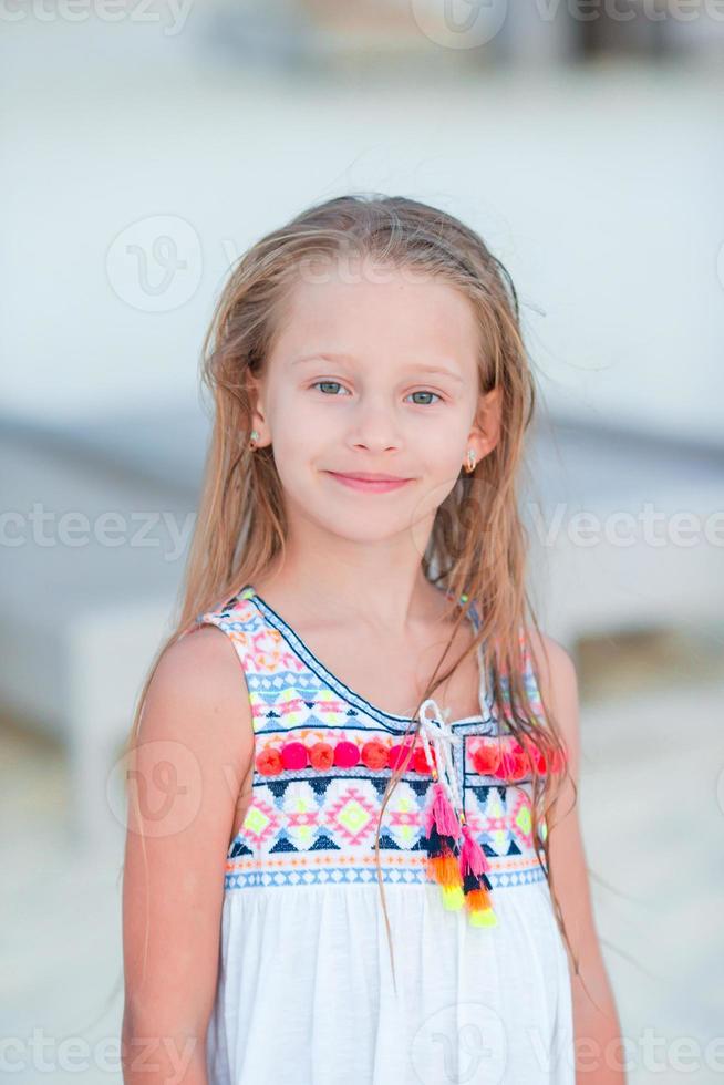 Adorable little girl at beach during summer vacation photo