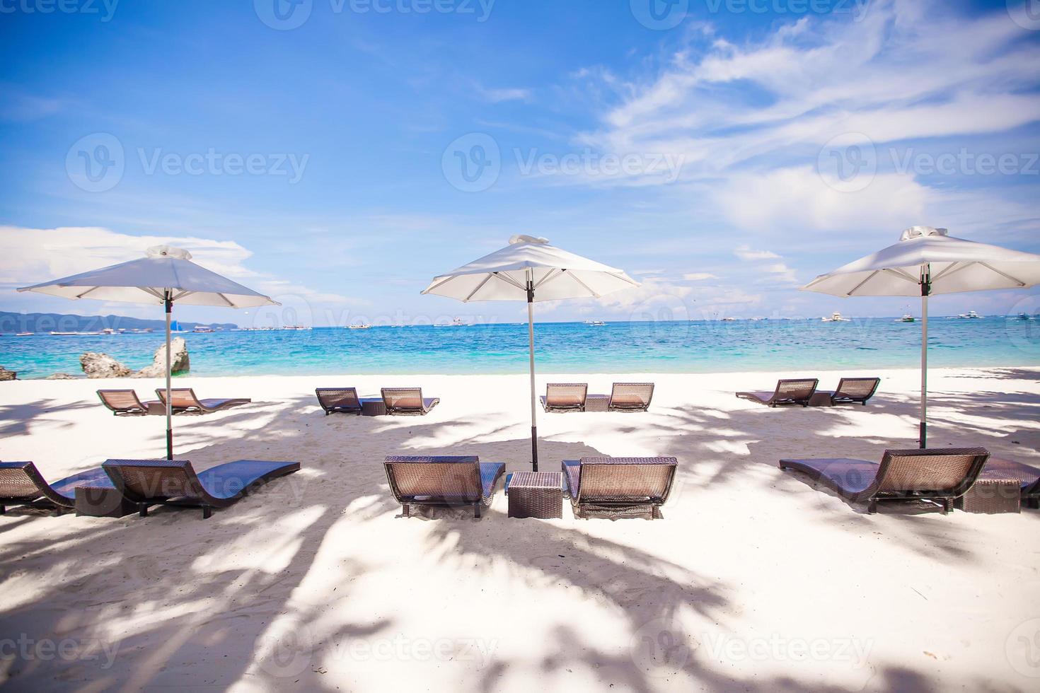 Paradise view of nice tropical empty sandy plage with umbrella and beach chair photo