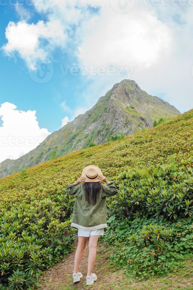 Beautiful happy young woman in mountains in the background of fog photo