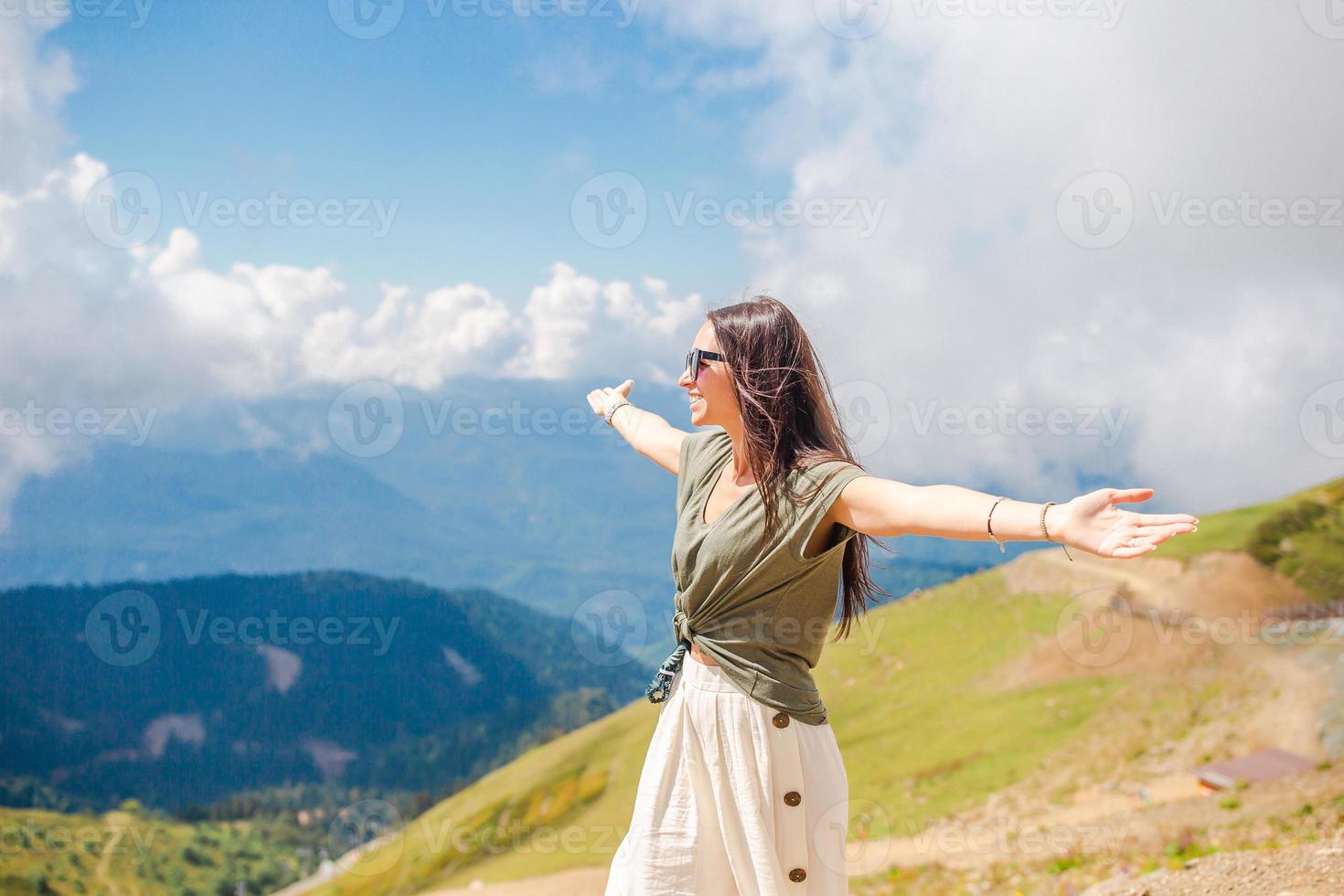 Beautiful happy young woman in mountains in the background of fog photo