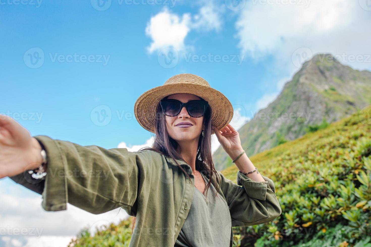 Beautiful happy young woman in mountains in the background of fog photo