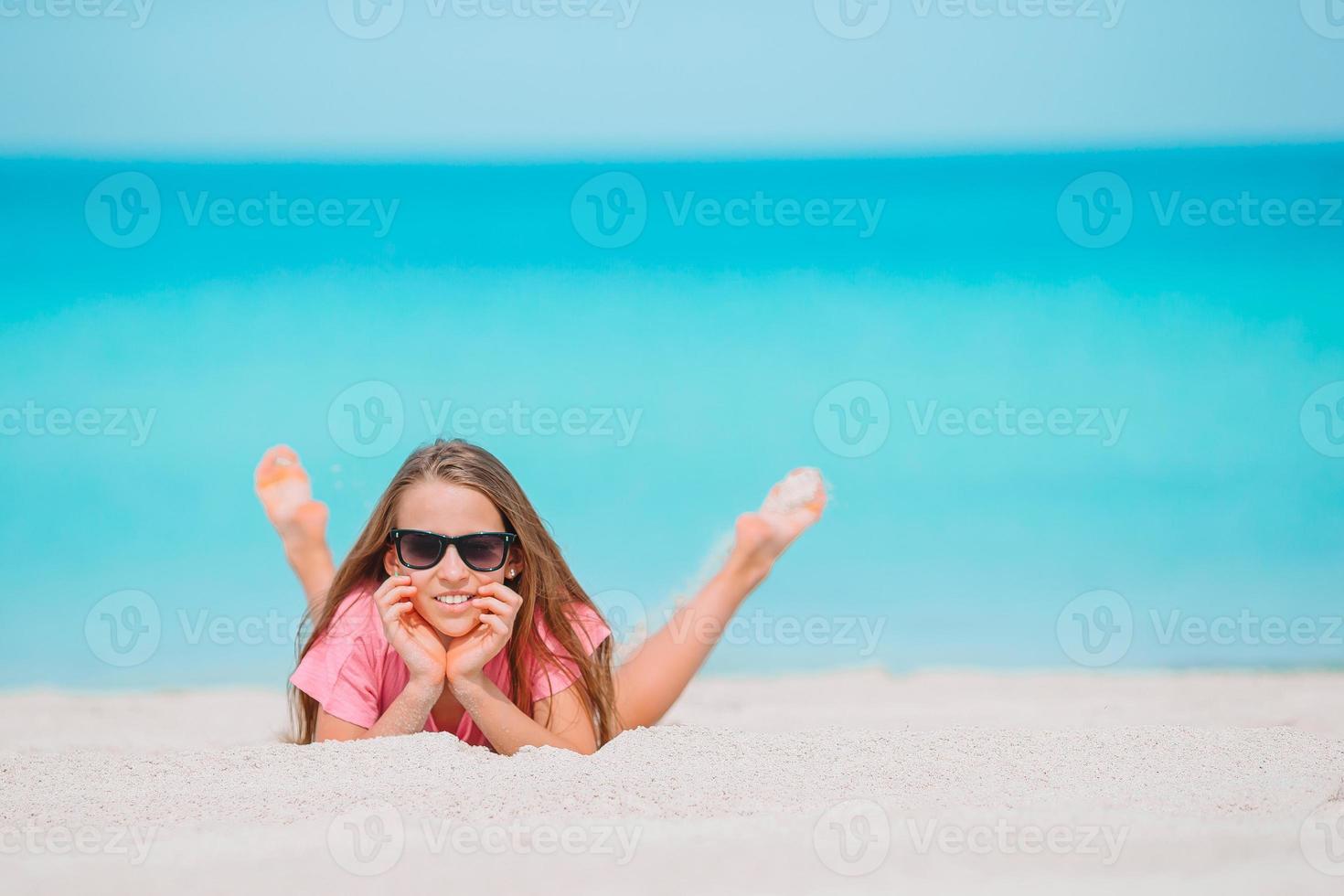 Adorable little girl have fun at tropical beach during vacation photo