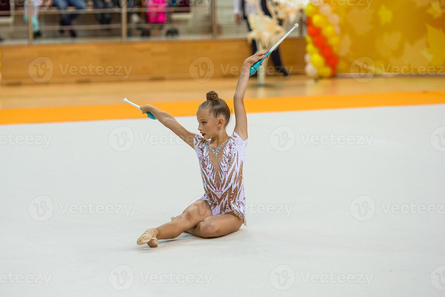 Beautiful little active gymnast girl with her performance on the carpet photo