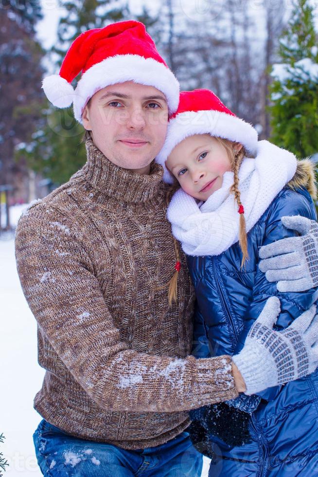 Happy family in Santa hats with christmas tree outdoor photo