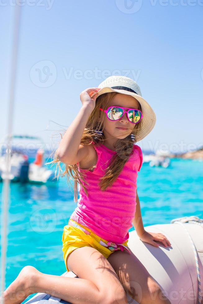 linda niña disfrutando de navegar en barco en el mar foto