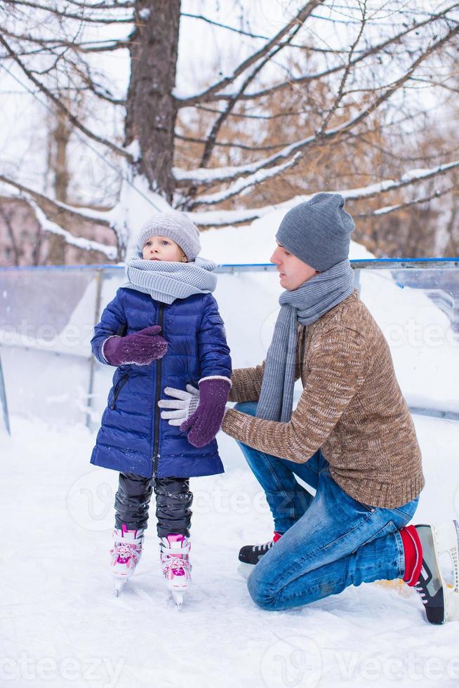 felices vacaciones de padre y niña en la pista de patinaje foto