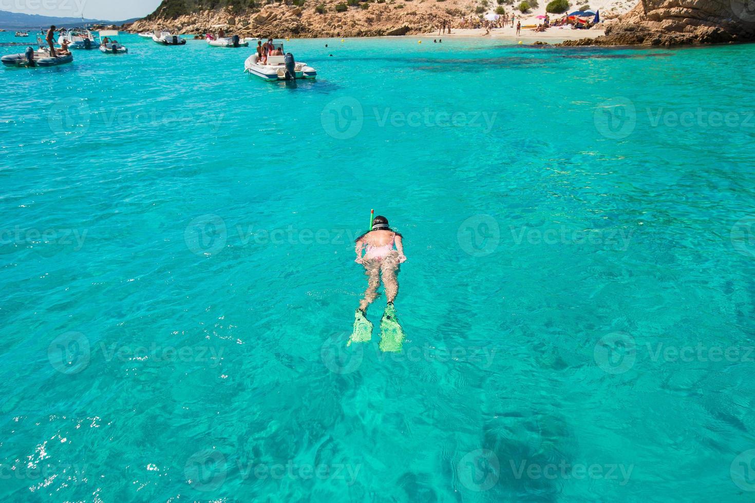 Beautiful girl snorkeling in clear tropical turquoise waters photo