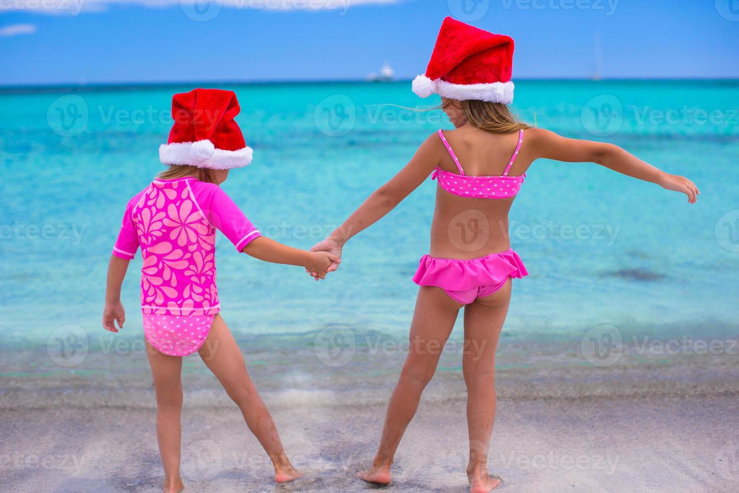 Little girls in Santa hats during summer vacation photo